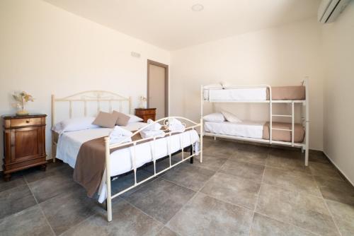 a bedroom with two bunk beds and a tiled floor at B&B Nonno Armando in Torchiara