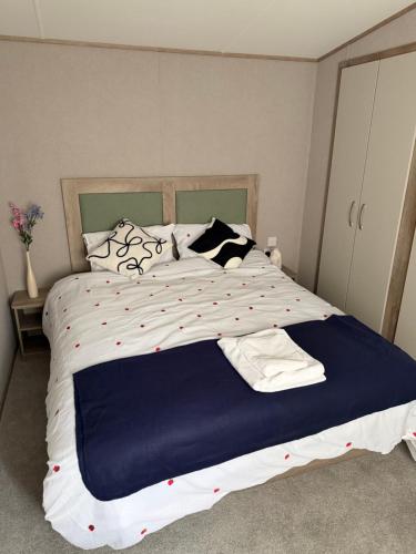 a large bed with a blue and white comforter at Diamond Touch Home in Saint Osyth