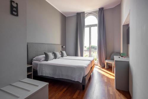 a bedroom with a large bed and a window at Hotel Villa Elisa & Spa in Bordighera