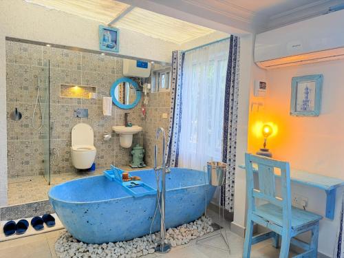 a large blue tub in a bathroom with a toilet at Studio Bleu by The Prime Escape in Arusha