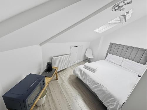a small bedroom with a bed and a tv at London Duo & Quad Rooms in Zone 2 - Willesden Green in London