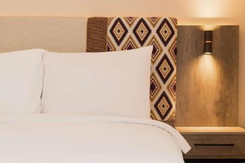 a bedroom with a bed with a white pillow at Apparemment à Radisson Blu Apartment Alhoceima Beach Access in Al Hoceïma