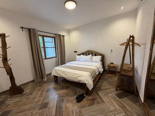 a bedroom with a bed and a wooden floor at City Retreat Mega in Arusha