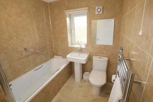 a bathroom with a toilet and a sink and a bath tub at Beckside Garden Brampton, ideal family cottage close to Hadrians Wall in Brampton