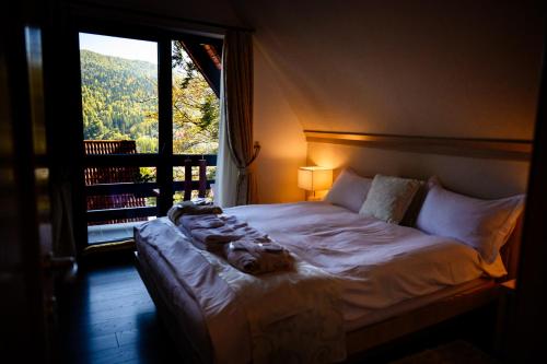 a bed in a room with a large window at Apartament Kalinderu K1 Bușteni in Buşteni