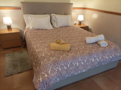 a bedroom with a bed with two towels and two lamps at Cávado Terrace Studio in Parada de Tibães