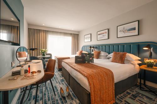 a hotel room with a large bed and a desk at Waterford Viking Hotel in Waterford