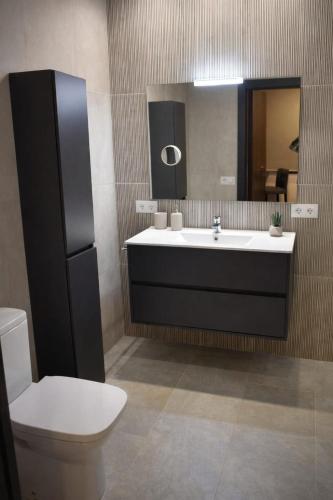 a bathroom with a sink and a toilet and a mirror at Petit Son Bauló in Can Picafort