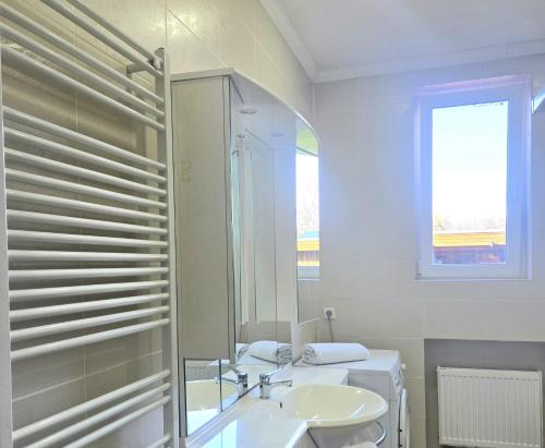 a white bathroom with a sink and a mirror at Leinstraße Ferienwohnung Neustadt in Neustadt am Rübenberge