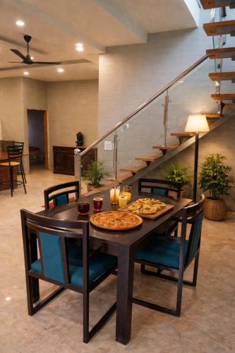 a dining room table with a pizza on it at The Machan Farmhouse in Noida