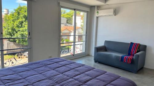 a bedroom with a bed and a couch and a window at Departamento Martinez San Isidro con AA y Wifi velocidad Ideal para quienes necesitan alojarse cerca de clínicas como Trinidad San Isidro Las Lomas o Fertilitis excelente acceso desde Panamericana y Thames espacio comodo tranquilo y totalmente equipado in Martínez