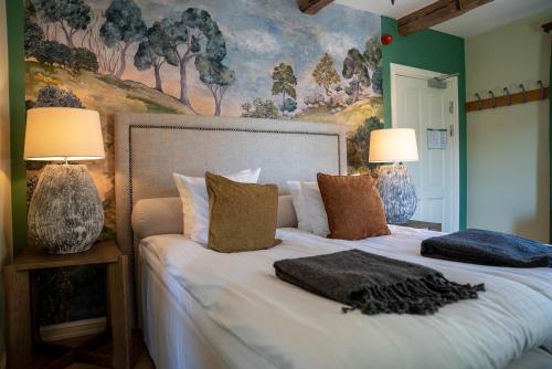 a bedroom with a large bed with two lamps at Farmors Lycka in Kivik