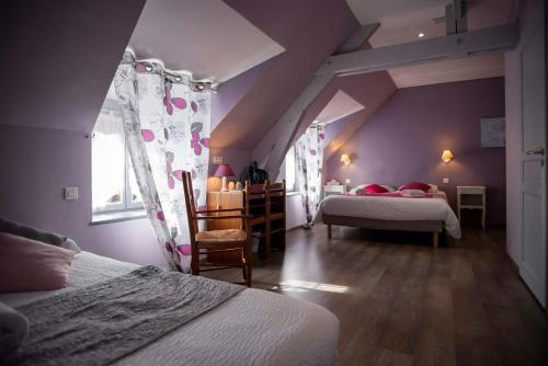 a attic bedroom with two beds and a dining room at Logis Hotels - Auberge de l'Île - Hôtel 3 étoiles et Restaurant in Creysse