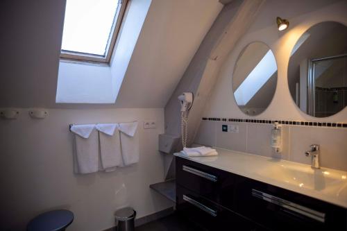 a bathroom with a sink and a mirror at Logis Hotels - Auberge de l'Île - Hôtel 3 étoiles et Restaurant in Creysse