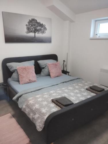 a bedroom with a bed with a tree on the wall at Apartmán u Révy in Bořetice