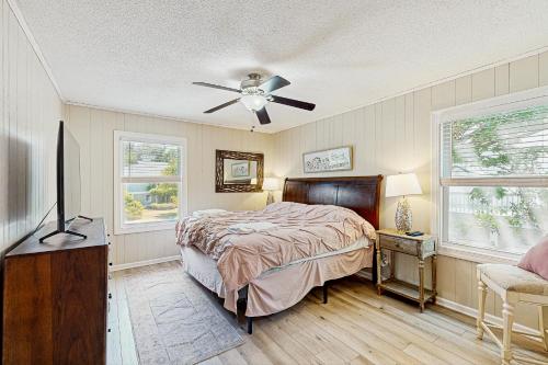 a bedroom with a bed and a ceiling fan at Sandy Feet Retreat in Kill Devil Hills