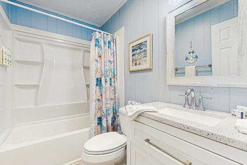 a bathroom with a toilet and a sink and a shower at Sandy Feet Retreat in Kill Devil Hills