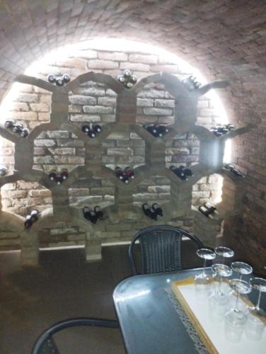 a stone wall with a table with wine glasses at Apartmán u Révy in Bořetice