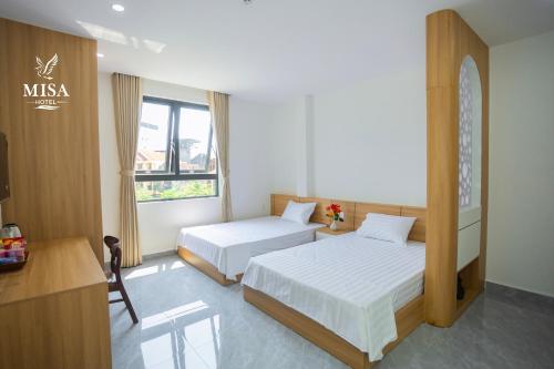 a hotel room with two beds and a television at MISA Hotel in Dong Hoi