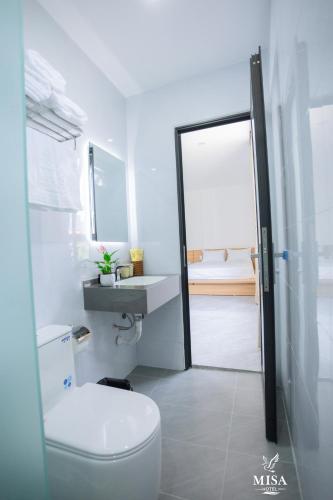 a bathroom with a toilet and a sink at MISA Hotel in Dong Hoi