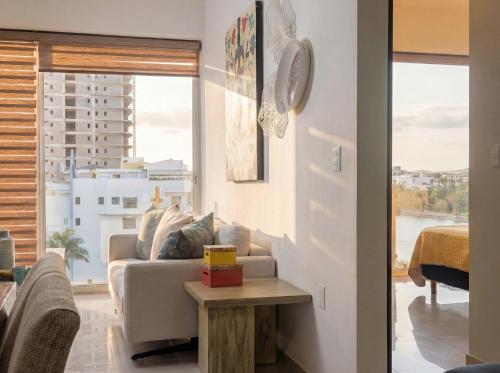 a living room with a couch and a large window at Luxurious 2 bedroom condo with partial ocean view in Mazatlán