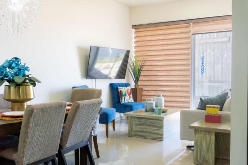 a living room with a table and a blue chair at Luxurious 2 bedroom condo with partial ocean view in Mazatlán