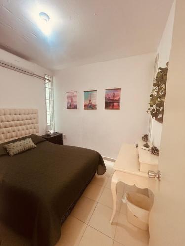 a bedroom with a bed and a white table at Arroyito Depto Pequeño in Tuxtla Gutiérrez