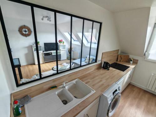 a kitchen with a sink and a large window at Superbe cocon de 44m2 in Longvic
