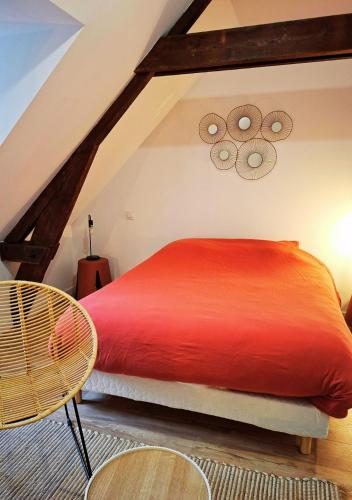a bedroom with a red bed and a chair at La Tour du Château in Fougères