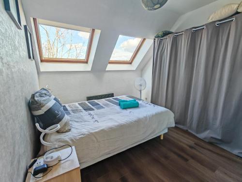 a bedroom with a bed in a room with a window at Superbe cocon de 44m2 in Longvic