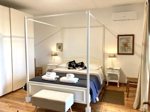 a bedroom with a white canopy bed with two towels at Holiday home Sellanraa in Campagnano di Roma
