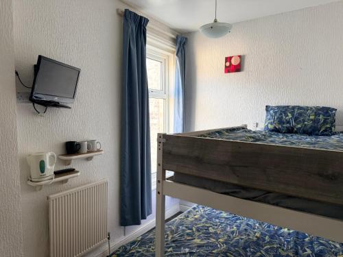 a bedroom with a bunk bed with a tv on the wall at Melrose Hotel in Blackpool