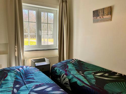 ein Schlafzimmer mit einem Bett und einem Fenster in der Unterkunft Unieke vakantiewoning met jacuzzi in de natuur in Het Laar