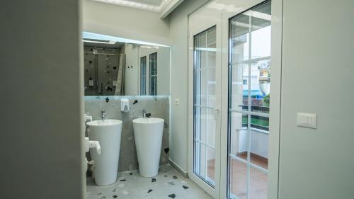 a bathroom with two urinals and a sink at 7even Boutique Hostel in Tirana