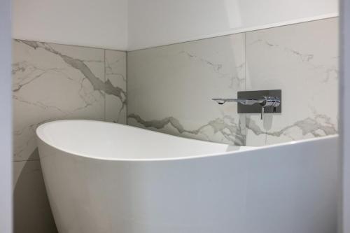 a bathroom with a white tub and a sink at Potovens Place in Lofthouse Gate