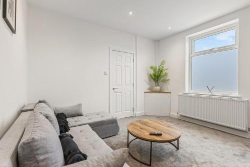 a living room with a couch and a table at Potovens Place in Lofthouse Gate