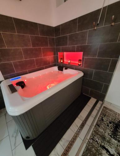 a bathroom with a red bath tub with a red light at Le Refuge Gabriel avec grand parking privé in Blois