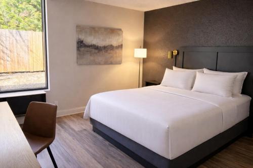 a bedroom with a large white bed and a chair at Hotel Arlington in Arlington