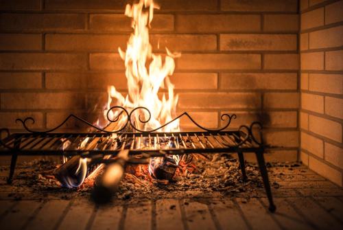 a fireplace with a bench in front of a fire at Alpenclub in Engelberg