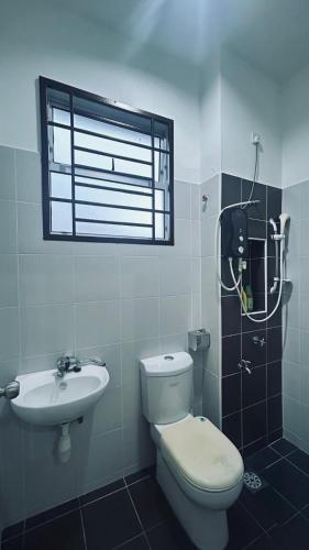 a bathroom with a toilet and a sink and a window at Alpha 2 in Johor Bahru