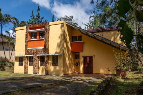 una casa amarilla con ventanas naranjas y una puerta roja en The Mexican, en Los Altos de Cerro Azul