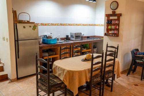 una cocina con una mesa y un refrigerador en The Mexican, en Los Altos de Cerro Azul