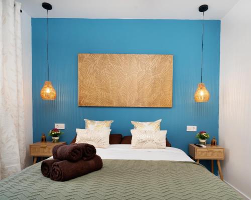 a bedroom with blue walls and a bed with towels on it at Bright Renovated 2BR Apt- Balcony - Beach 10' Walk - Barcelona 25' Train in Sant Adria de Besos