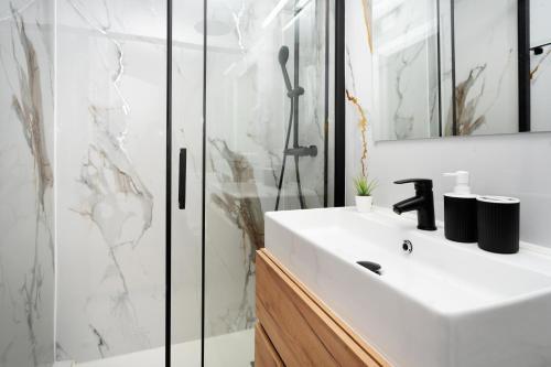 a bathroom with a white sink and a shower at Bright Renovated 2BR Apt- Balcony - Beach 10' Walk - Barcelona 25' Train in Sant Adria de Besos