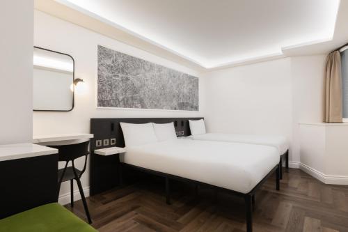 a room with a bed and a desk at STG Hotel Oxford Street - formerly St Giles London Hotel in London