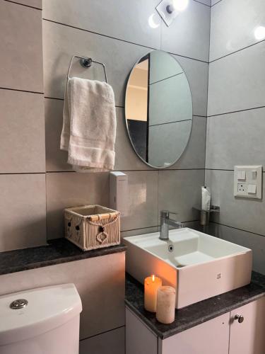 a bathroom with a sink and a mirror and a toilet at Sukhhin Chandigarh in Zirakpur
