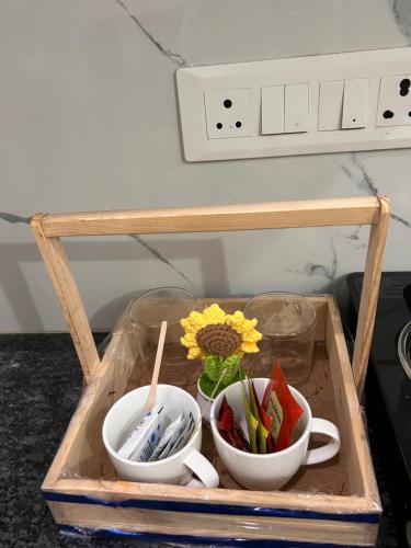 a tray with three bowls and a vase with a flower at Sukhhin Chandigarh in Zirakpur