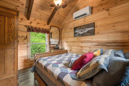 a bedroom with a bed in a wooden cabin at Cedar Heights Tiny House Log Cabin in Bryson City