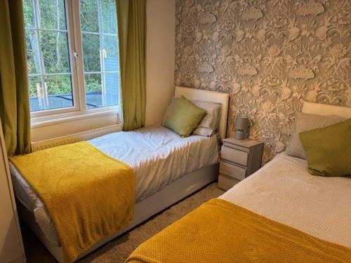 a bedroom with two beds next to a window at Bramble Lodge in West Chevington