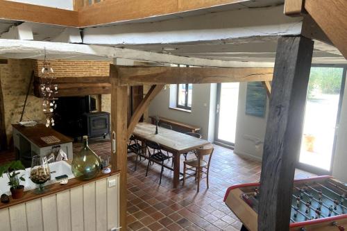 a kitchen and a dining room with a table in a room at La Maison de Fougerolles, Renovated farmhouse in Fougerolles